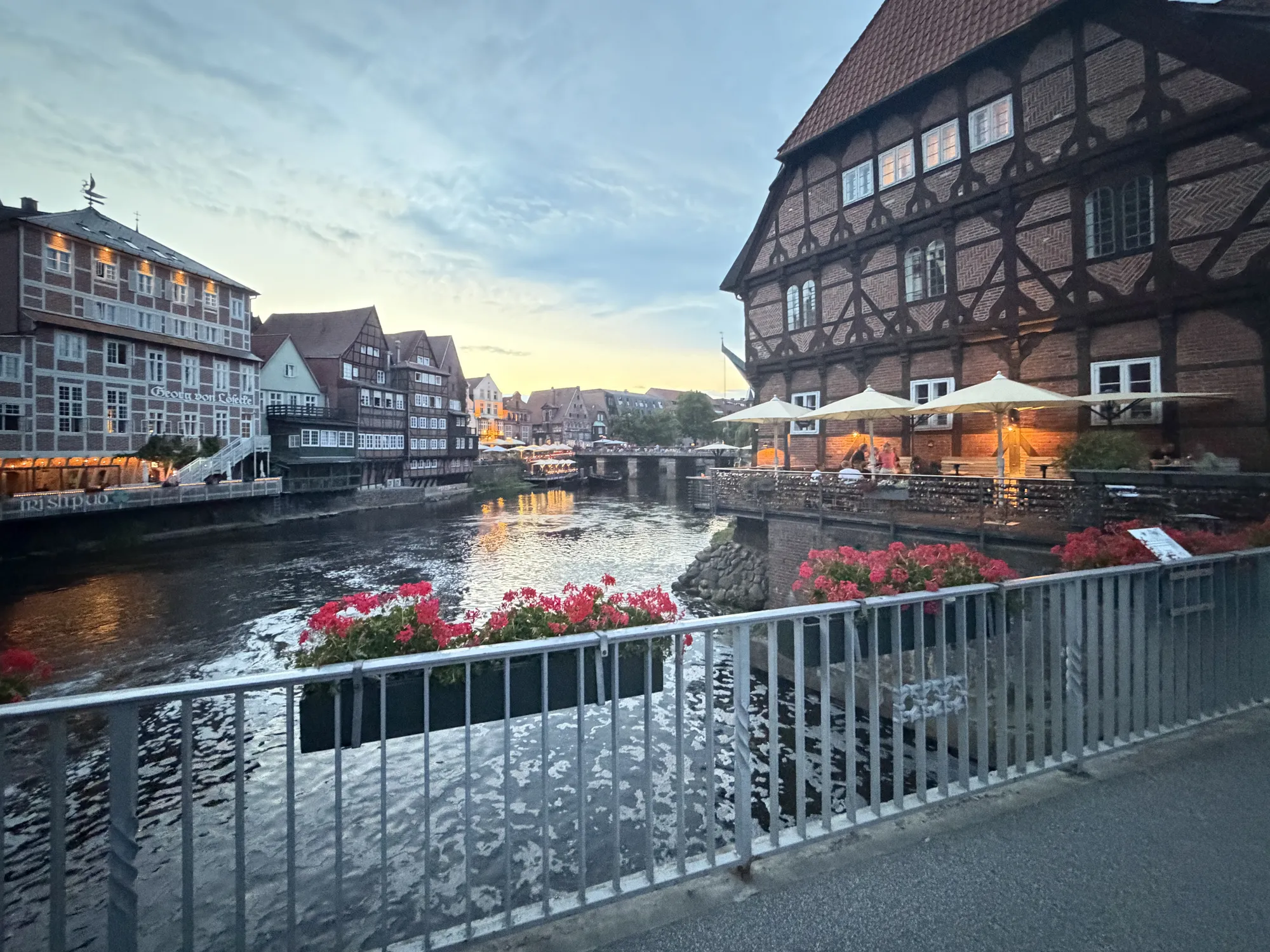Historische Fachwerk- und Backsteinhäuser am Stintmarkt im Lüneburger Wasserviertel an der Ilmenau am Abend